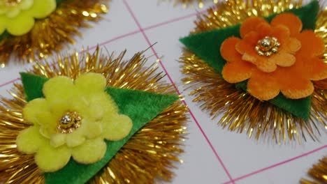 handmade multiple colours of rakhi with floral design and golden tinsel decoration. interior shot, push in, 4k