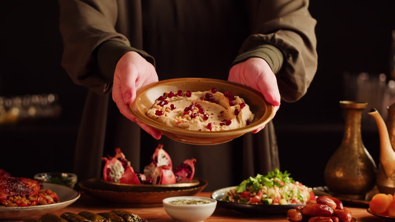 una mujer sirviendo hummus.