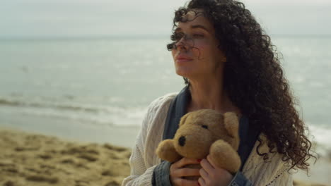 Beautiful-lady-relaxing-beach-seaside.-Hispanic-woman-playing-plush-toy-outside.