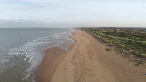 Tourist-Walking-On-Sand-Dune-At-The-Shoreline-Of-North-Sea-Beach-In-South-Holland,-Netherlands