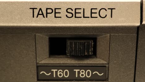 Extreme-Nahaufnahme-Der-Tasten-An-Einem-Alten-Antiken-Oder-Vintage-Videorecorder,-Ein-Schalter,-Der-Von-Einem-T60-Band-Auf-Ein-T80-Band-Wechselt-Und-Den-Schalter-Umlegt