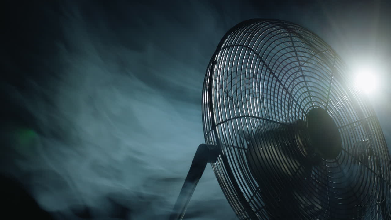 팬 블레이드는 빛과 안개의 광선에서 회전합니다.