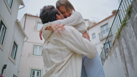 abrazando cónyuges disfrutando del amor ciudad mediterránea de cerca. hombre girando mujer