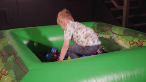 young happy boy playing in a ball pit