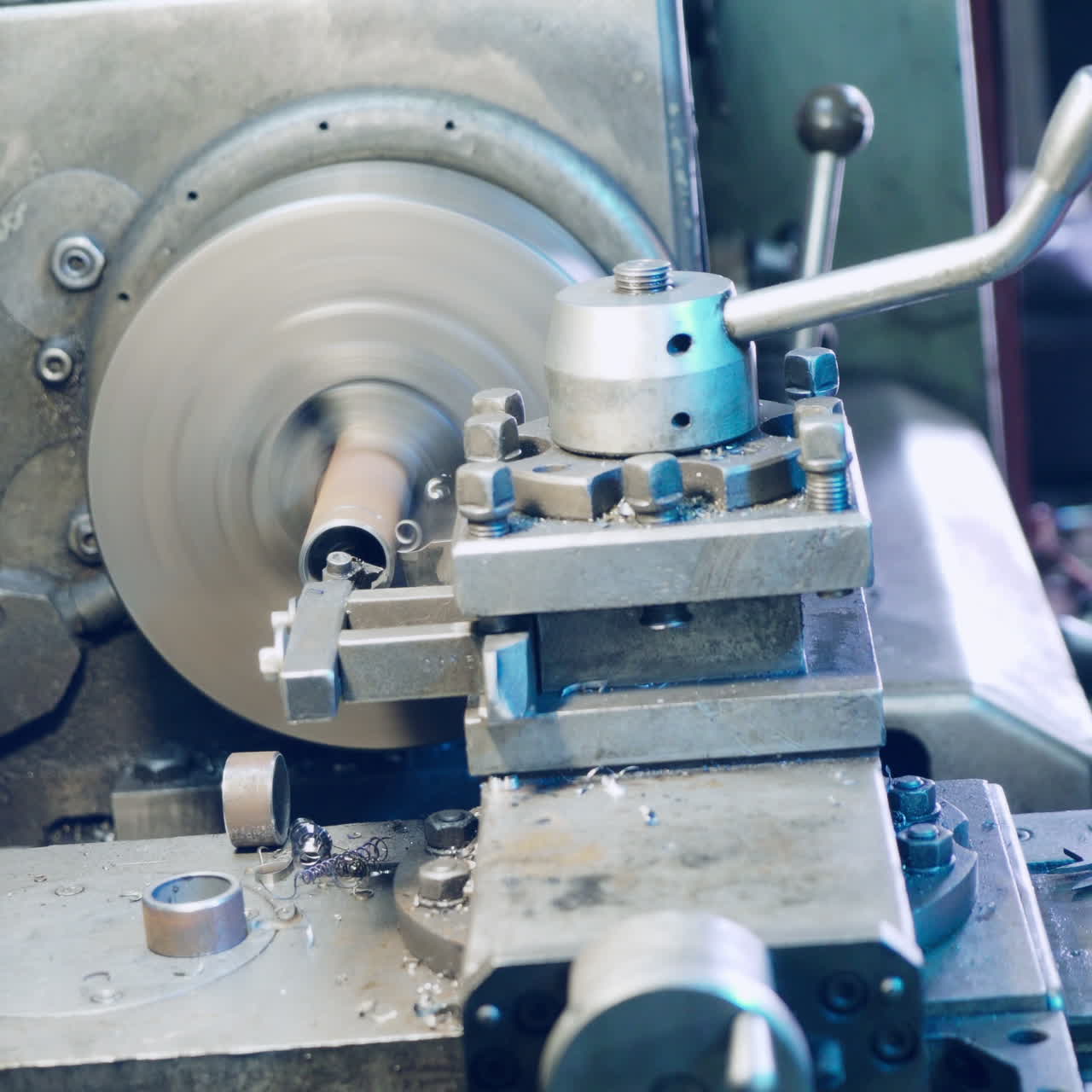 Close up hand heavy industrial worker is working on metal work factory process by performing mechanical turning operation at machine for steel structure industry