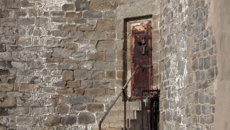 rusted dungeon-like prison door in wall of eastern state penitentiary