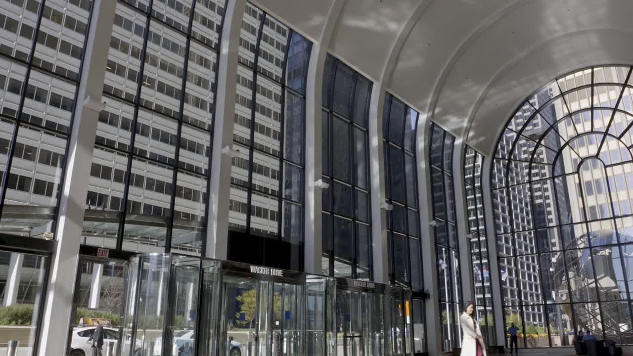 Sunlit lobby of a modern office building in downtown Chicago with people walking by