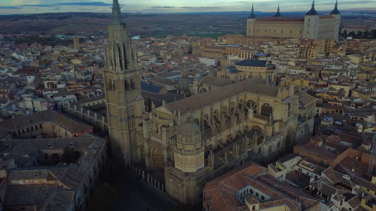 Drone circling round gothic Catedral Primada de Toledo with Alcázar behind - Toledo, Spain