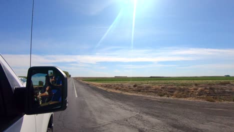 POV-out-of-the-passenger's-side-window-while-driving-past-harvested-wheat-fields-in-an-agricultural-area-of-Eastern-Washington-State