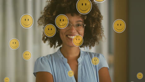 animación de iconos emoji sobre una feliz mujer biracial