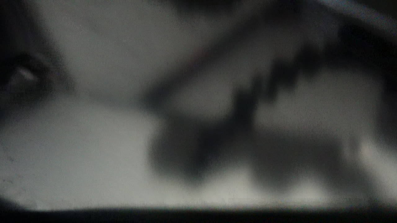 Barbecue on a sailboat is opened to reveal hamburgers cooking with cheese and buns being toasted hands flipping them