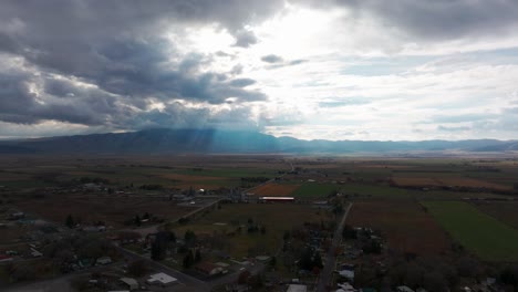 drone shot of rural farm land after a storm with mountains in the distance