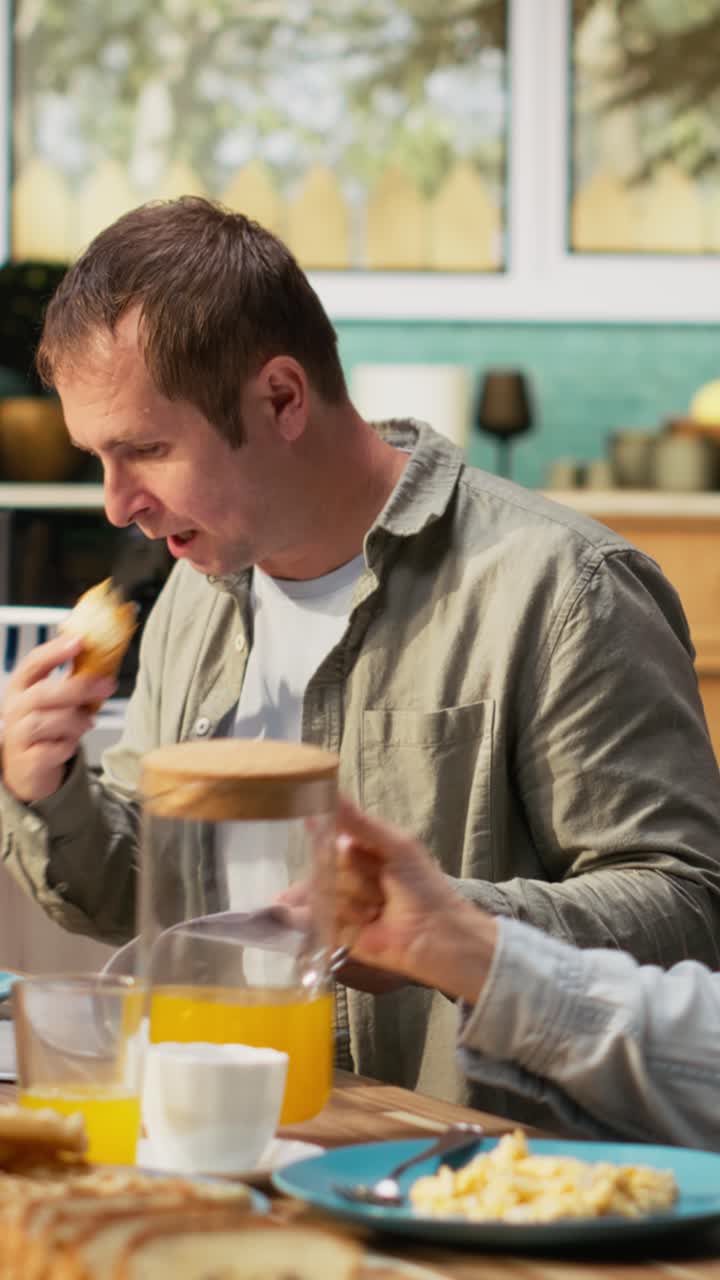 Vertical Video Preoccupied working dad studying work reports and documents at breakfast