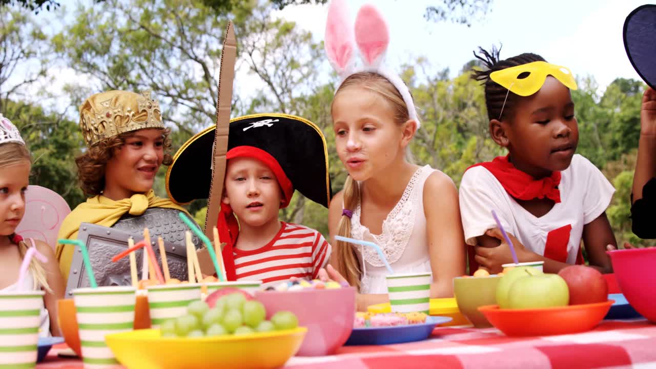 grupo de niños en varios trajes tomando el desayuno