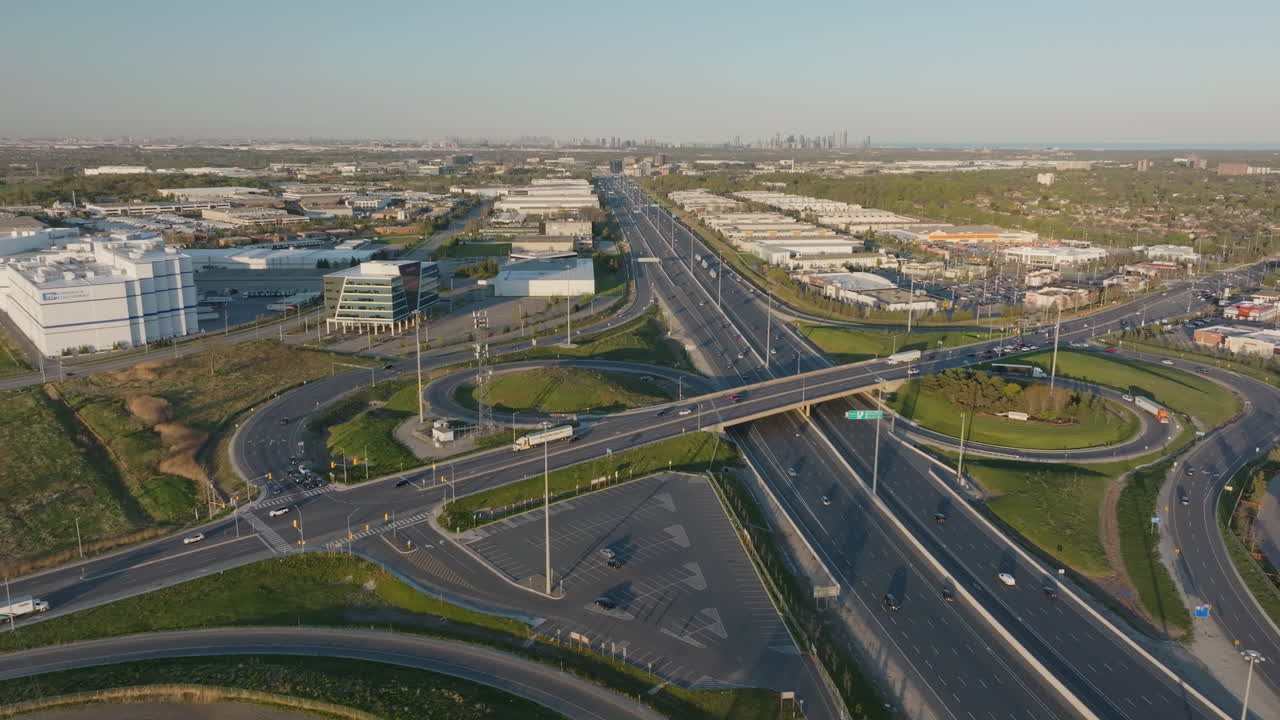 Wide aerial view of a highway interchange in Mississauga, Ontario, with industrial buildings