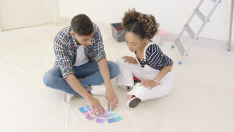 pareja mirando muestras de pintura para decorar