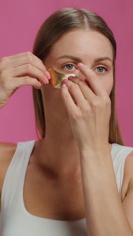 woman applying gold face mask