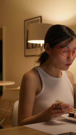 mujer comiendo sushi en casa