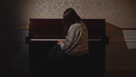 woman playing piano in elegant interior