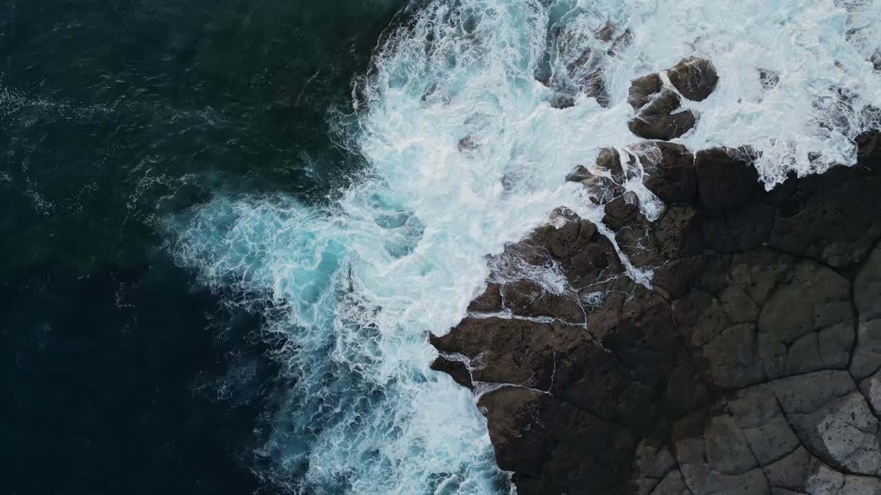Veduta dall'alto con drone di onde oceaniche che si infrangono contro la costa rocciosa a Tenerife, Isole Canarie