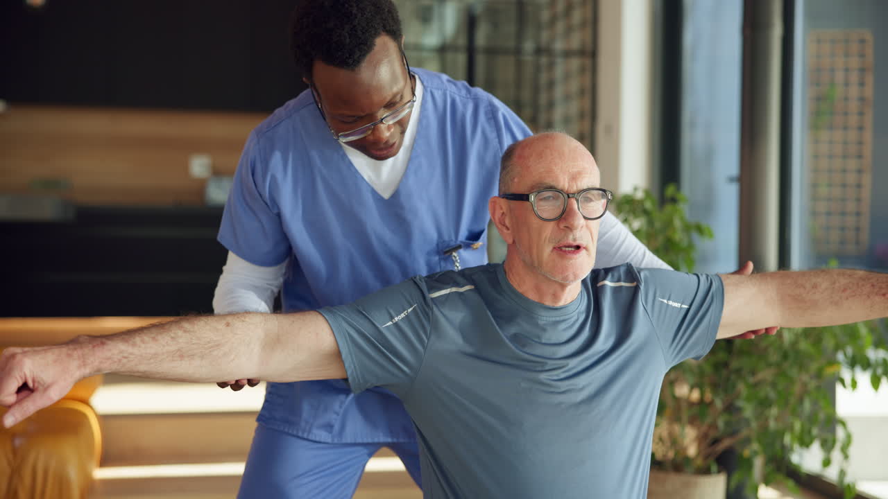 Physiotherapist Assisting Elderly Man with Rehabilitation Exercises
