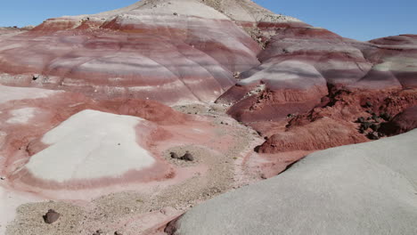 Aerial-view-low-over-red-cliffs-in-Bentonite-Hills,-sunny-day-in-Utah,-USA