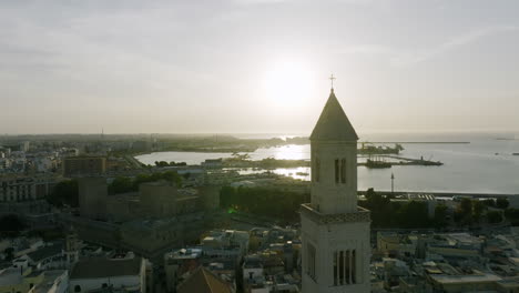 Aerial-footage-flying-towards-the-cross-on-top-of-the-steeple-of-the-the-church-spire-on-the-Basilica-Cattedrale-Metropolitana-Primaziale-San-Sabino-in-Bari,-Italy