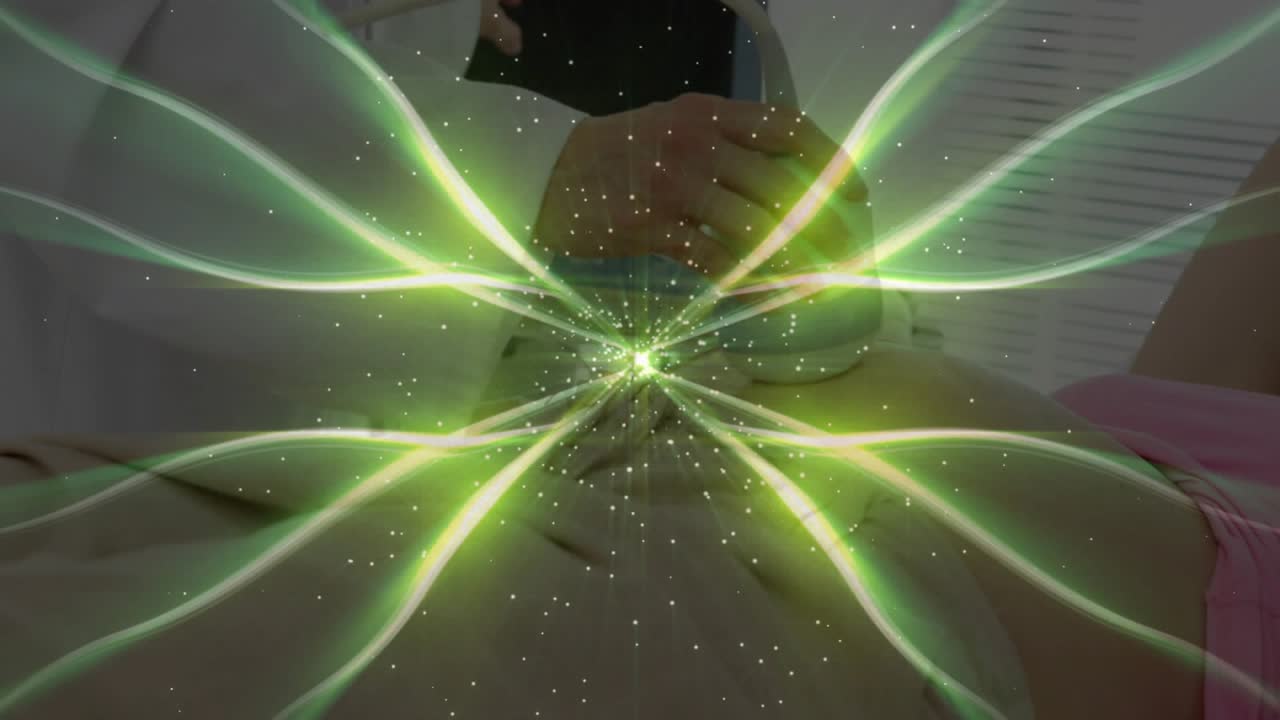 Profesional escaneando el abdomen de un paciente con un dispositivo que produce energía verde que se desvanece al final en una clínica