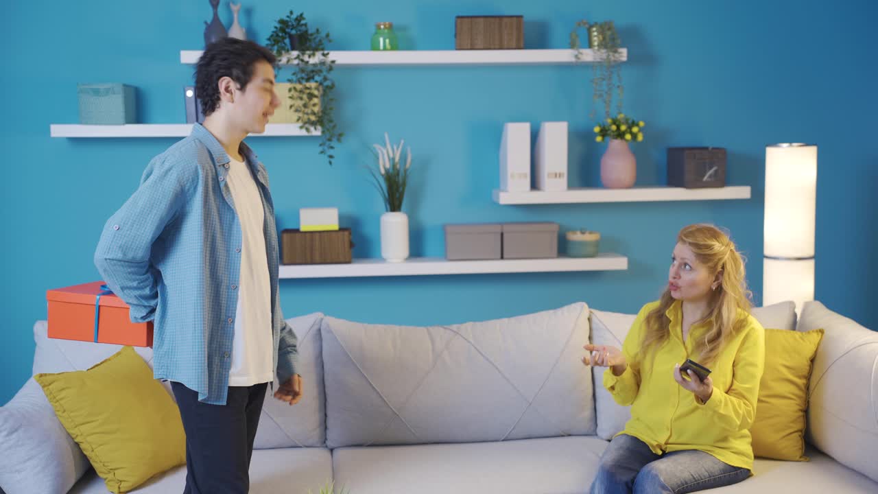 젊은 남자가 어머니를 놀라게 하기 위해 선물을 사고 있습니다.