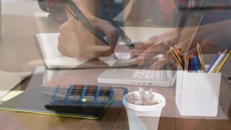 Animation-of-mid-section-of-person-writing-with-warehouse-in-background