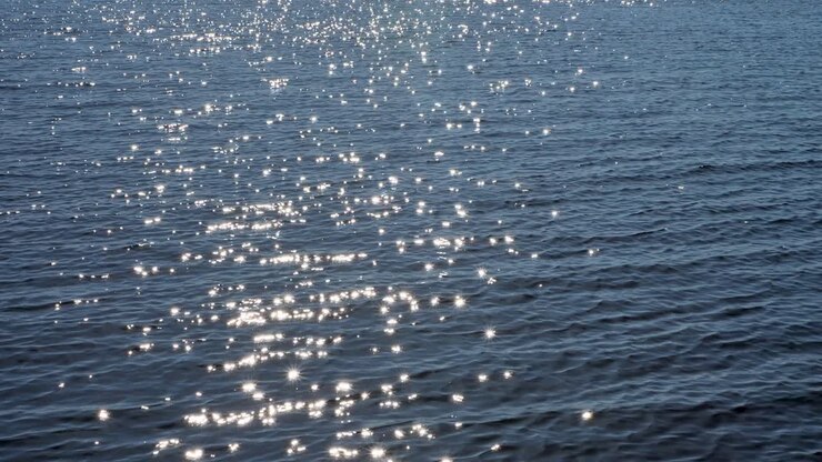 The surface of the lake in a light wind with the reflection of sun glare