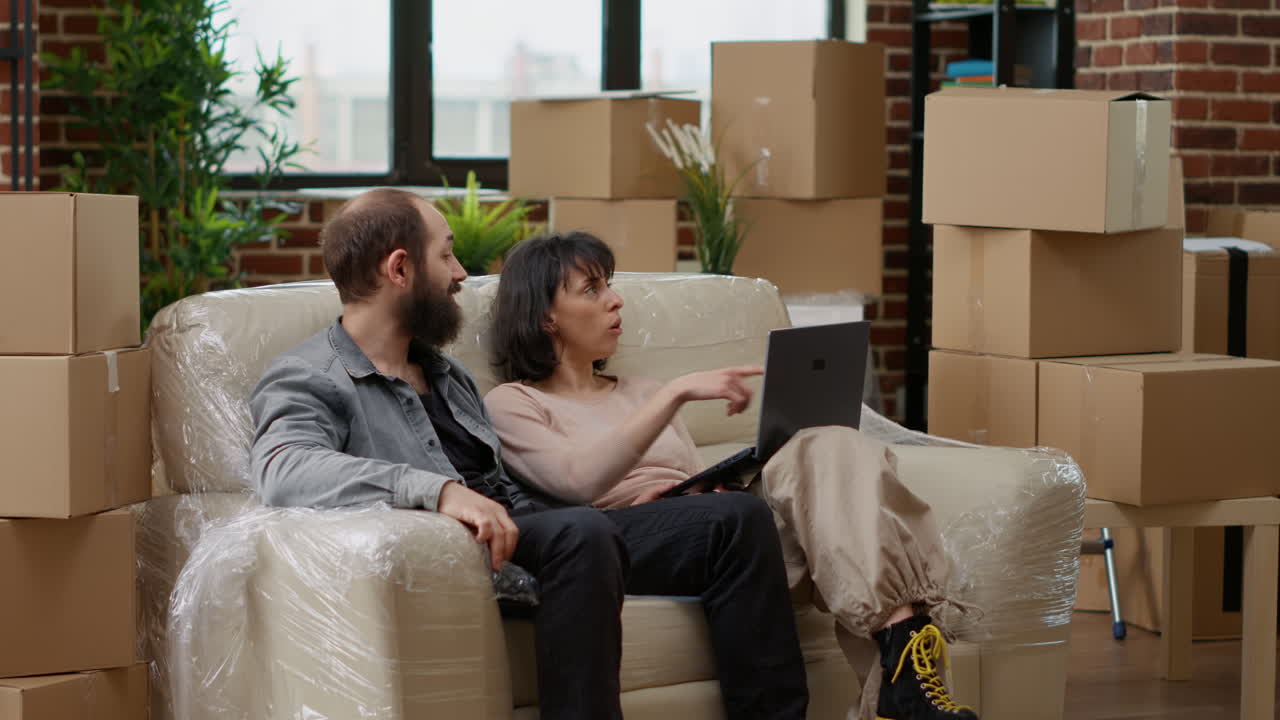 Husband and wife buying home furniture online on laptop
