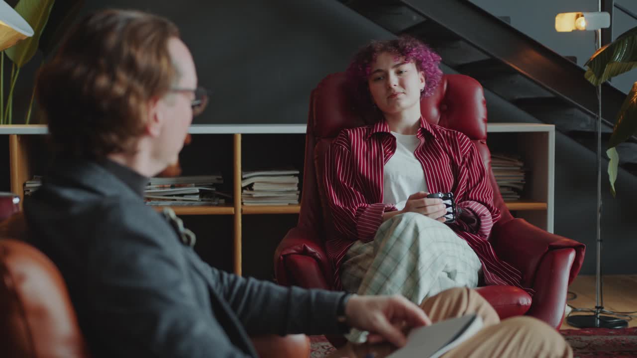 Young Woman with Prosthetic Arm Speaking with Colleague or Therapist in Office