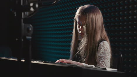 young girl playing piano in a recording studio