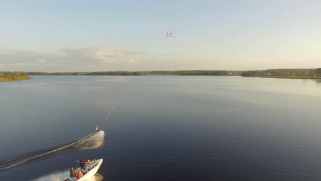 Un-Gran-Dron-Tirando-De-Un-Wakeboard-Mientras-Una-Lancha-Lo-Sigue-De-Cerca---Vista-Aérea