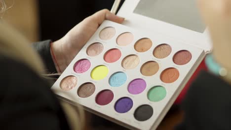 A-professional-makeup-artist-works-with-an-eyeshadow-palette-of-various-colors