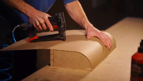 using a nail gun to attach wood paneling