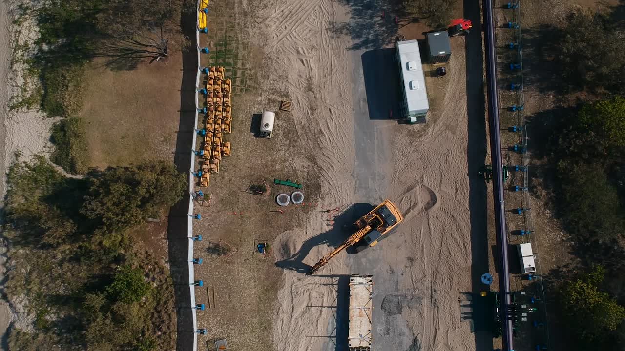 un sitio de construcción cerca de una ciudad importante que realiza obras de infraestructura en una península costera para instalar servicios a una población en crecimiento