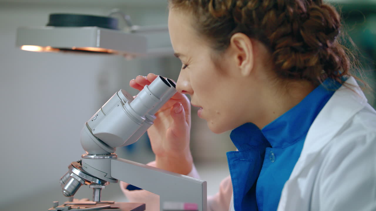 mujer científica mirando el microscopio. primer plano del microscopio científico