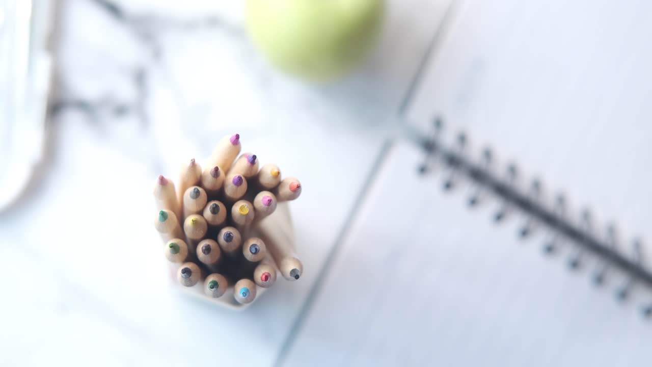 la mano del niño recogiendo lápices de colores