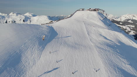 skiers go down the ski slope on ski resort in saalbach-hinterglemm, austria - drone shot