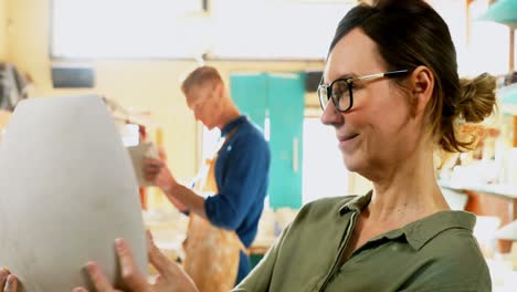 Male-and-female-potter-interacting-while-working-4k