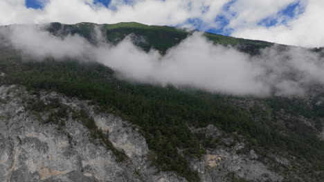 mountain peak with clouds and forest