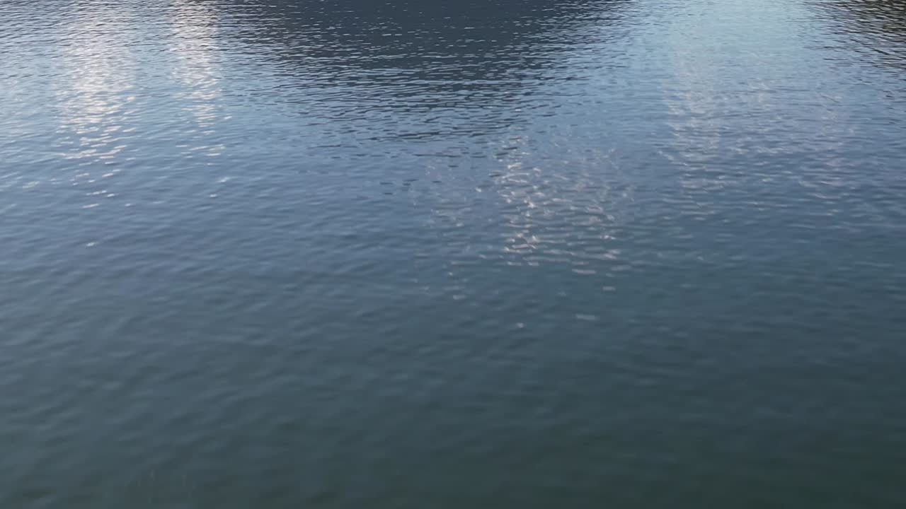 Drone view of serene lake reflecting peaks in the Italian Alps