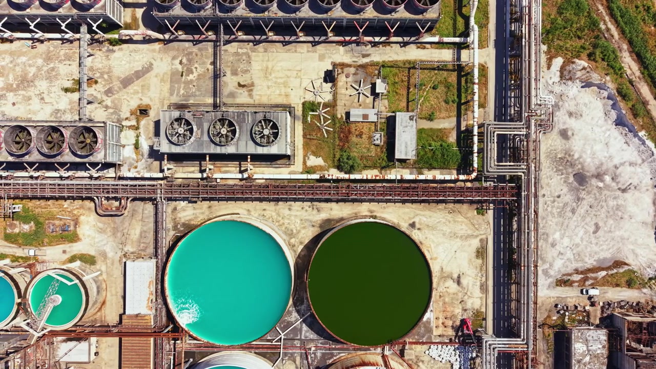 Large industrial facility with water treatment tanks in an aerial view above processing area during daytime