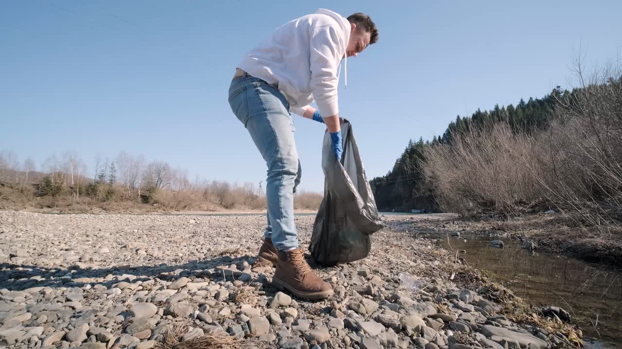 trabajo en equipo limpiando plástico en la playa. voluntarios recogen basura en una bolsa de basura. contaminación plástica y concepto de problema ambiental. limpieza voluntaria de la naturaleza del plástico. ecologización del planeta