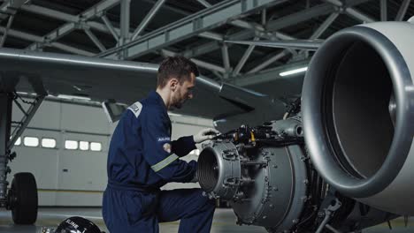 aircraft mechanic working on jet engine