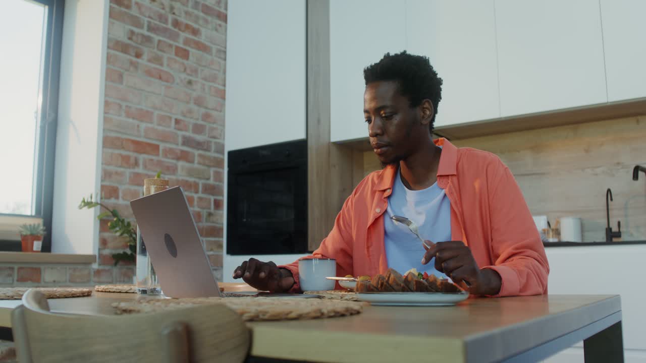 hombre desayunando mientras trabaja desde casa