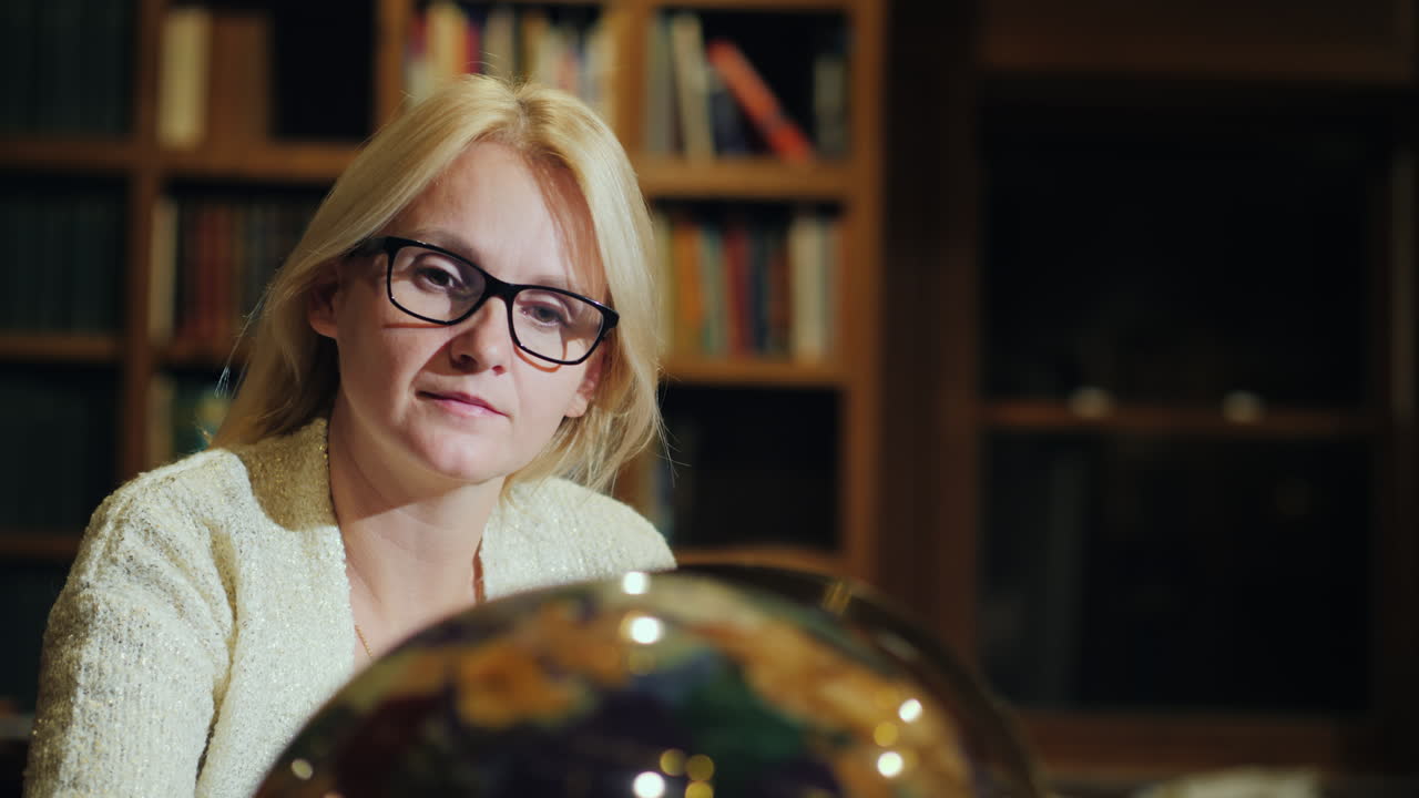 una mujer mira un hermoso globo en la biblioteca