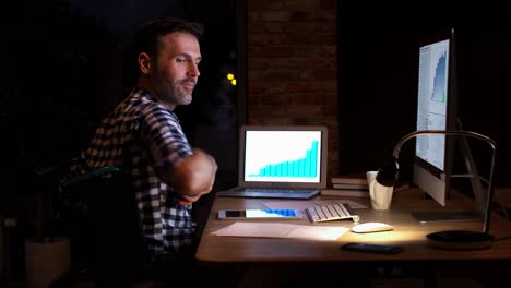 Smiling-man-talking-by-mobile-phone-in-his-home-office